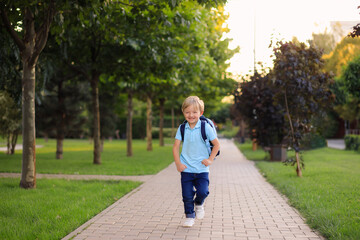 Fototapeta premium The child after school runs to his parents. Back to school.