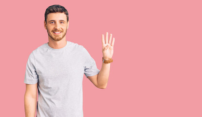 Handsome young man with bear wearing casual tshirt showing and pointing up with fingers number four while smiling confident and happy.