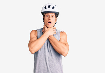 Young handsome man wearing bike helmet shouting and suffocate because painful strangle. health problem. asphyxiate and suicide concept.