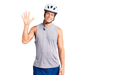Young handsome man wearing bike helmet showing and pointing up with fingers number five while smiling confident and happy.