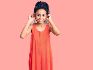 Cute african american girl wearing casual clothes smiling pulling ears with fingers, funny gesture....