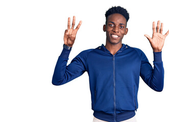Fototapeta premium Young african american man wearing sportswear showing and pointing up with fingers number eight while smiling confident and happy.