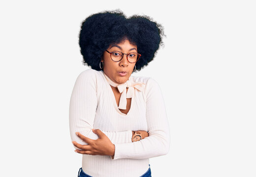 Young african american girl wearing casual clothes and glasses shaking and freezing for winter cold with sad and shock expression on face