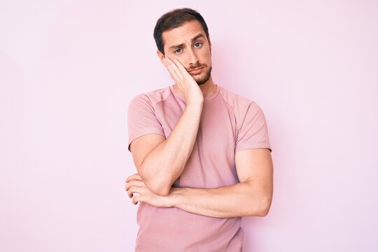 Young handsome man wearing casual tshirt thinking looking tired and bored with depression problems with crossed arms.