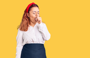 Young latin woman wearing waitress apron feeling unwell and coughing as symptom for cold or bronchitis. health care concept.