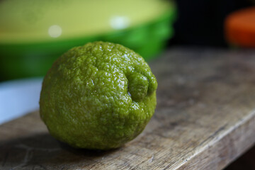 closeup green lemon with a wooden backdrop