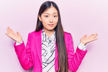 Young beautiful chinese woman wearing elegant clothes clueless and confused with open arms, no idea...