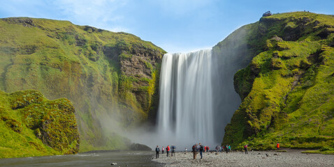 Fototapeta premium Iceland waterfall Skogafoss in Icelandic nature landscape. Long exposure of Famous tourist attraction and landmarks destination in Icelandic nature landscape on South Iceland.