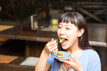 カフェでケーキを食べる女性