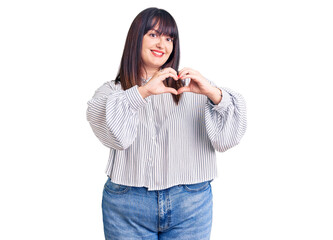 Young plus size woman wearing casual clothes smiling in love doing heart symbol shape with hands. romantic concept.