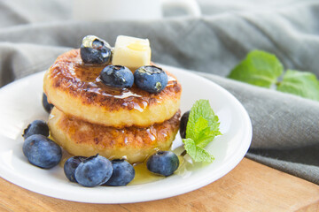 A healthy breakfast of pancakes, berries, butter, and honey