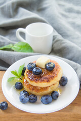 A healthy breakfast of pancakes, berries, butter, and honey