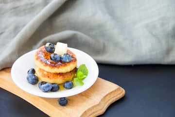 A healthy breakfast of pancakes, berries, butter, and honey