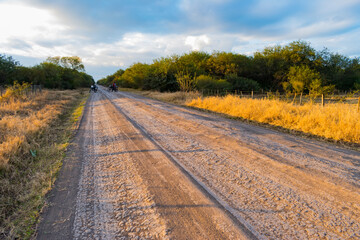 camino rural con personas en motocicleta