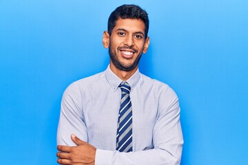 Young latin man wearing business clothes happy face smiling with crossed arms looking at the camera. positive person.