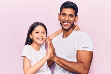 Obraz premium Young father and daughter wearing casual clothes praying with hands together asking for forgiveness smiling confident.