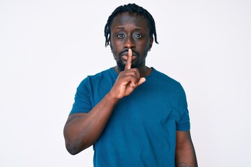 Young african american man with braids wearing casual clothes asking to be quiet with finger on lips. silence and secret concept.