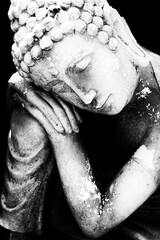 High contrast close up of peaceful weathered Buddha sculpture 