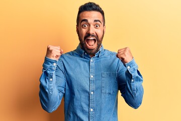 Young hispanic man wearing casual clothes celebrating surprised and amazed for success with arms raised and open eyes. winner concept.