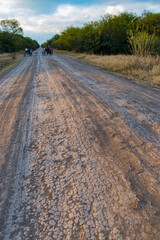camino rural con personas en motocicleta