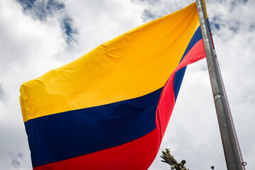 Colombia flag waving in a blue cloudy sky