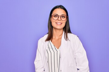 Young beautiful brunette psychologist woman wearing coat and glasses over purple background with a happy and cool smile on face. Lucky person.
