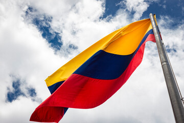 Colombia flag waving in a blue cloudy sky