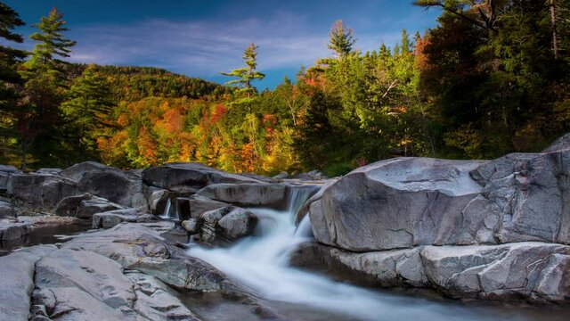 Brilliant autumns colored leaves in New Hampshire Near the Kancamagus highway with smooth waterfall