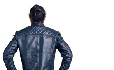Young arab man wearing casual leather jacket standing backwards looking away with arms on body