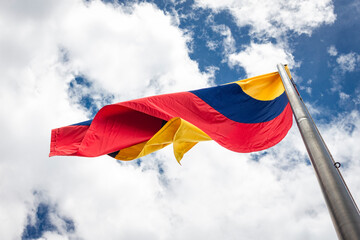 Colombia flag waving in a blue cloudy sky