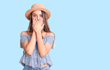 Young beautiful girl wearing hat and t shirt shocked covering mouth with hands for mistake. secret concept.
