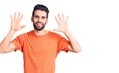 Naklejka premium Young handsome man with beard wearing casual t-shirt showing and pointing up with fingers number ten while smiling confident and happy.