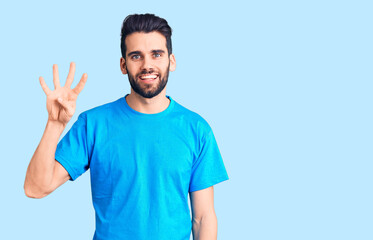 Obraz premium Young handsome man with beard wearing casual t-shirt showing and pointing up with fingers number four while smiling confident and happy.
