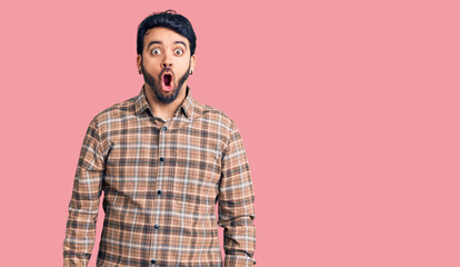 Young hispanic man wearing casual clothes afraid and shocked with surprise and amazed expression, fear and excited face.