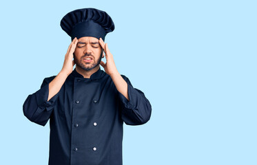 Young hispanic man wearing cooker uniform with hand on head for pain in head because stress. suffering migraine.