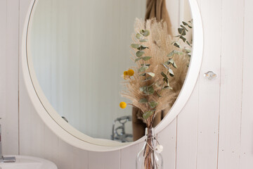 flowers in a vase in front of a mirror in a bathroom bedroom