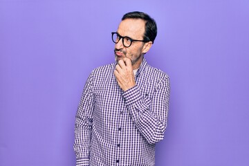 Fototapeta premium Middle age handsome man wearing casual shirt and glasses over isolated white background thinking concentrated about doubt with finger on chin and looking up wondering