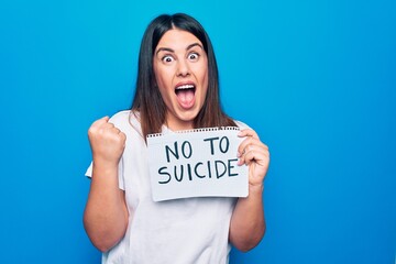 Young beautiful woman asking for psychical problem holding paper with not to suicide message...