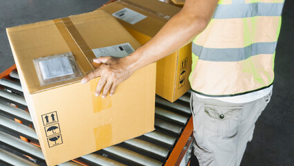 Distribution warehouse, parcel, Shipment, Worker working on a conveyor, his sorting carton boxes for delivering to a customer.