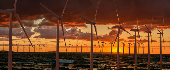 Wind farm in the sea during sunset