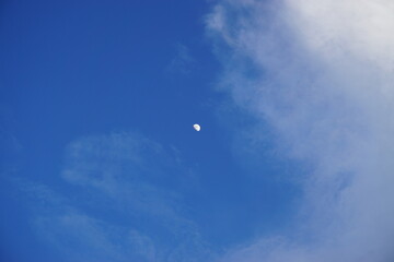 The moon in the blue sky.