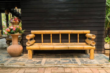 Bamboo wood bench decoration at wooden garden background. Bamboo armchair decorative with large...