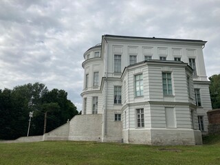 Facade of luxury estate with stairs. From below exterior of luxury mansion with staircase and many windows on sunny summer day