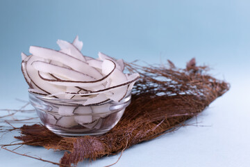 Natural homemade chips in a glass bowl on a dried palm leaf on a blue background. Snacks prepared...