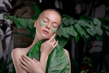 Beautiful woman with eye patches and tropical leaf. Female perfect smooth skin. Organic, natural cosmetics, skin care, cosmetology, spa, wellness