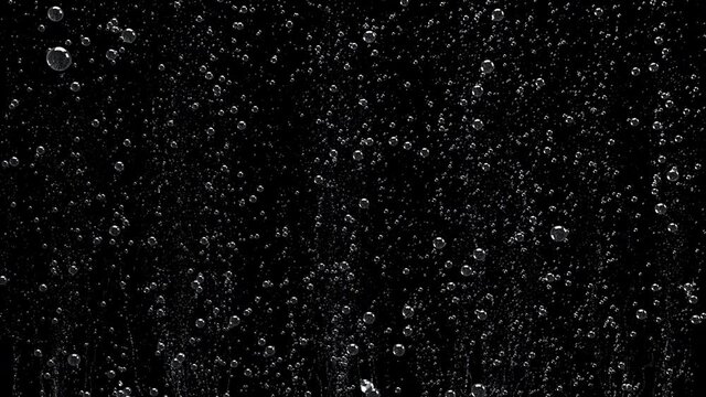 Close-up of bubbles air in under water floating up to water surface. 
The camera moves through bubbles. Isolated on black background. Alpha channel included in the end of the clip.