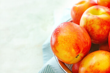 Sweet ripe nectarines in colander on table, closeup