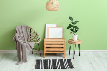 Wooden chest with armchair near color wall in room