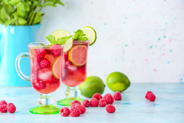 Cups of cold raspberry tea on table