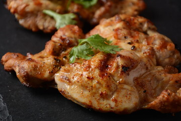 Grilled chicken steaks with tomatoes, herbs, olive oil, pepper,sliced cucumber and herbs.